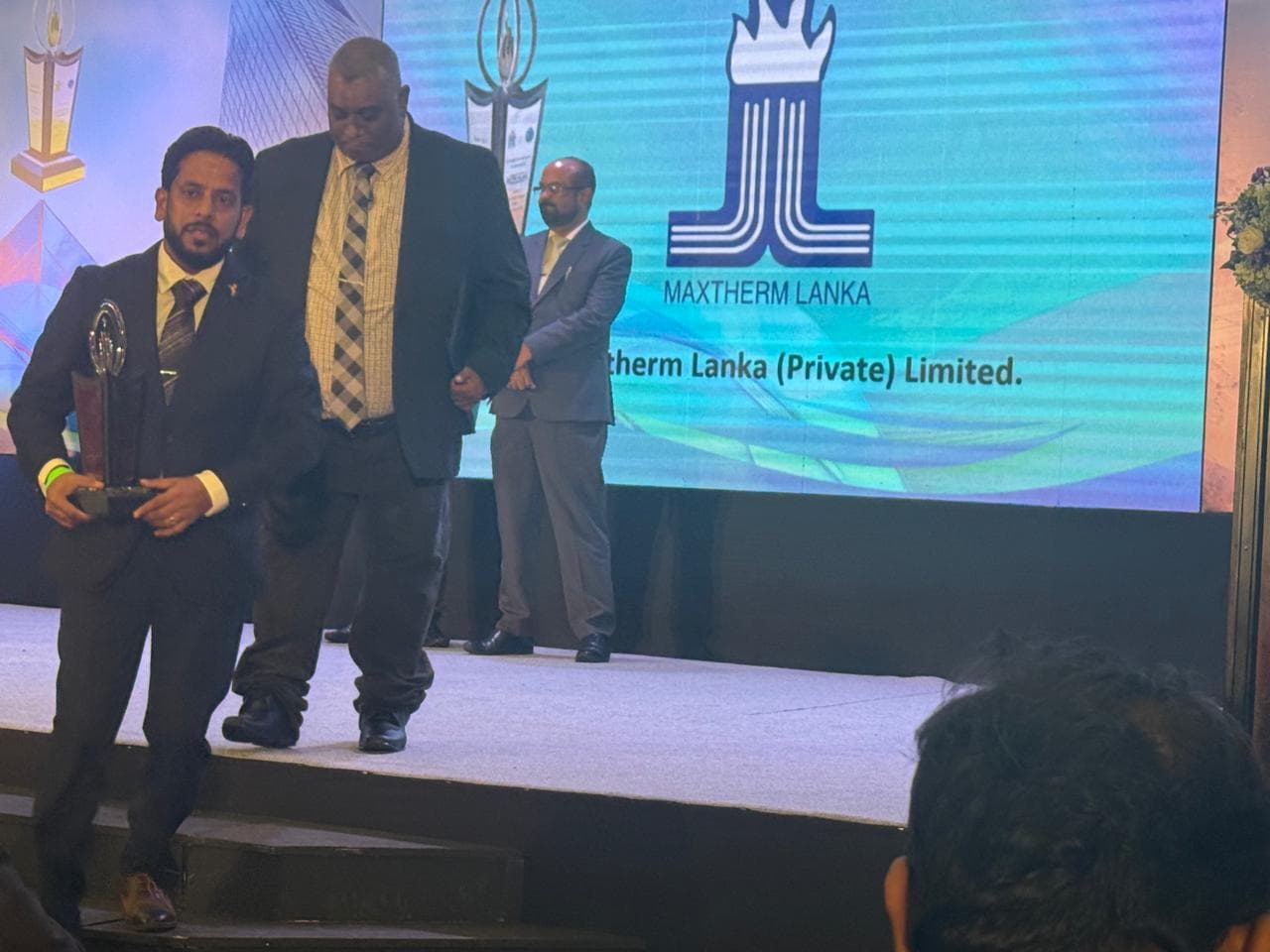 Maxtherm Lanka receiving the Silver Flame trophy on stage